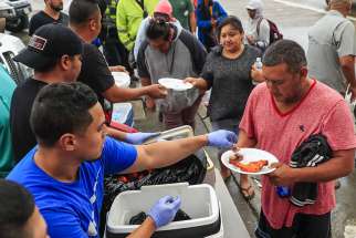Evacuees are given a meal Aug. 29 after being rescued from their neighborhoods in the aftermath of Tropical Storm Harvey in Houston.