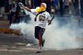 An anti-government protester throws a tear gas canister back at police during a March 10 protest in Caracas, Venezuela. Bishops in Caracas urged both the government and protesters to resist violence amid a deepening standoff in Venezuela that has further polarized the country and left church charities struggling.