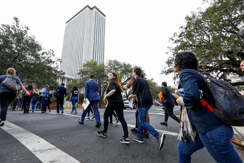 Students from Marjory Stoneman Douglas High School in Parkland, Fla., cross a street in Tallahassee prior to speaking with Florida state legislators Feb. 20 at the Capitol. About 100 students from the Parkland school traveled in a three-bus caravan to demand gun restrictions a week after the deadly shooting that left 17 of their classmates and teachers dead.