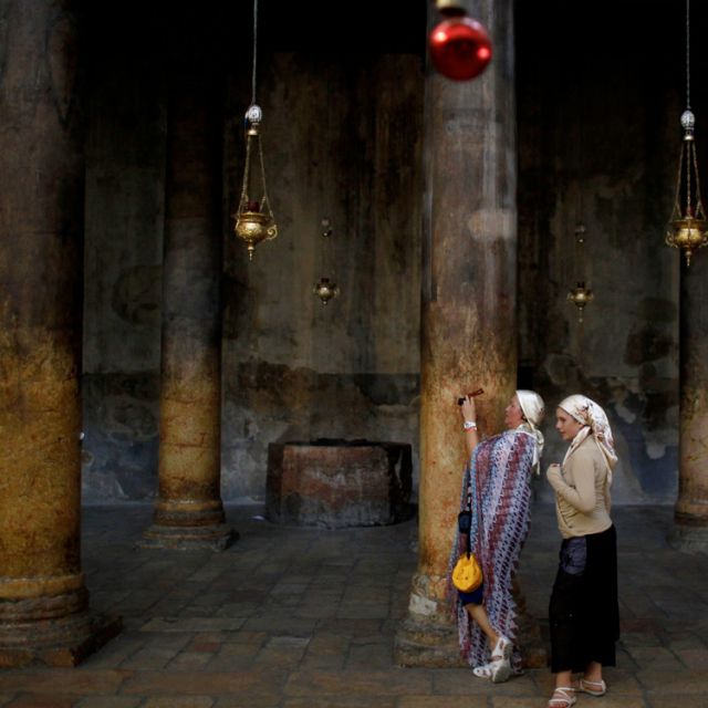 A tourist takes a photograph in the Church of the Nativity, the site revered as the birthplace of Jesus, in the West Bank town of Bethlehem June 28. UNESCO declared parts of Bethlehem and the church endangered World Heritage sites to expedite funding for repairs.