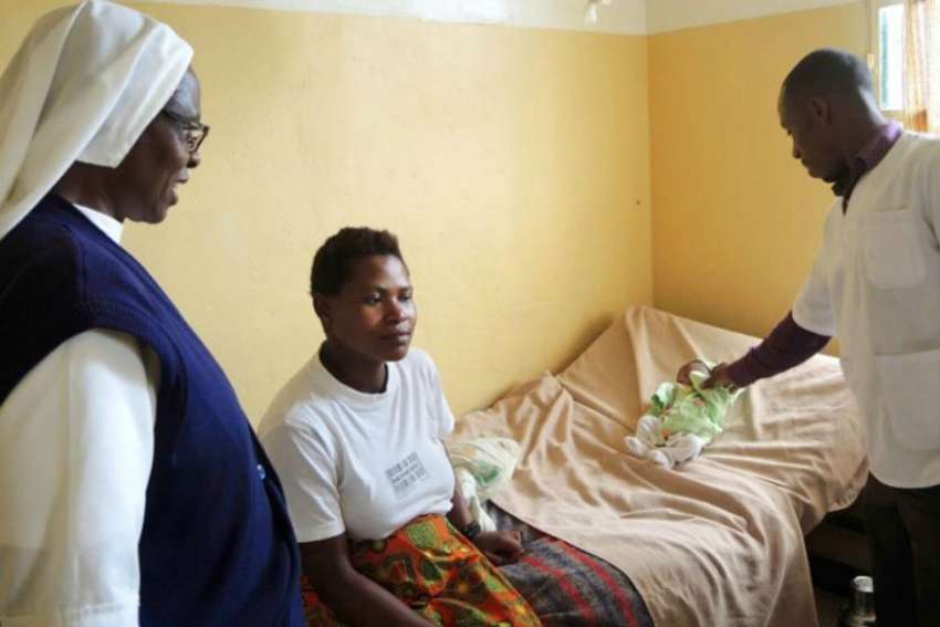 Sr. Margaret Wanjiku Njunguna, left, and a nurse check up on a newborn baby with a cold at the health centre in Muyanza, Rwanda.