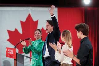 Prime Minister Justin Trudeau, accompanied by his wife, Sophie Gregoire, and their children, waves to supporters during the Liberal election night party in Montreal Sept. 20.