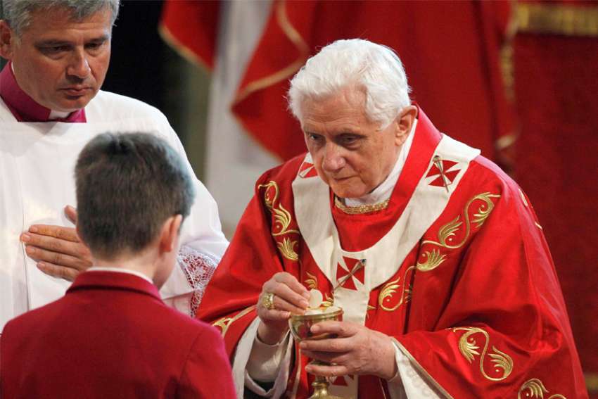 Pope Benedict XVI gives Communion to a young man during Mass at Westminster Cathedral in London in this Sept. 18, 2010, file photo. During the service the pope expressed his &quot;deep sorrow&quot; to the victims of clerical sexual abuse, saying these crimes have caused immense suffering and feelings of &quot;shame and humiliation&quot; throughout the church.
