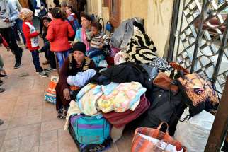 Displaced Egyptian Christian families, who used to live in the north of the Sinai Peninsula, sit near their belongings after arriving Feb. 24 at a church in Ismailia. Catholic churches in Ismailia, with help from Caritas, have helped Coptic Orthodox fleeing Islamic State attacks in North Sinai.