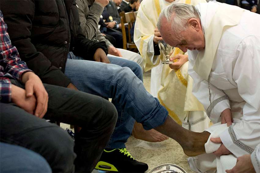 Pope Francis washes the foot of an inmate during the Holy Thursday Mass at Casal del Marmo prison for minors in Rome in this March 28, 2013, file photo. Pope Francis will celebrate Mass March 29 at Rome&#039;s Regina Coeli prison and wash the feet of 12 inmates. 