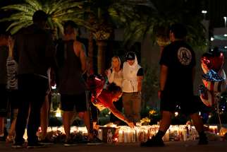 People comfort each other during an interfaith memorial for mass shooting victims led by Bishop Joseph Pepe of Las Vegas, the evening of Oct. 2.
