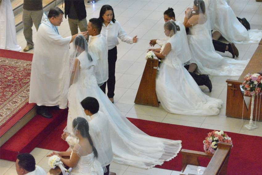 Couples receive Communion during a mass wedding in 2015 at St. Alphonsus Mary de Ligouri Church in Makati City, Philippines. A Philippine Catholic official expressed surprise over the speedy acceptance of legislation that would legalize divorce in the Philippines.