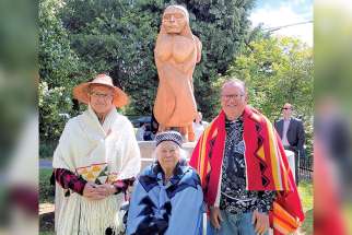 From left, Jason Nahanee, who carved the memorial statues, Barb Wyss, chair of the Eslahn Social Society who spearheaded the memorial project, and Deacon Rennie Nahanee, who worked with Wyss to plan the memorial and with the Archdiocese of Vancouver to have it placed on the property of St. Thomas More Regional Secondary, former site of St. Paul’s Indian Residential School. 