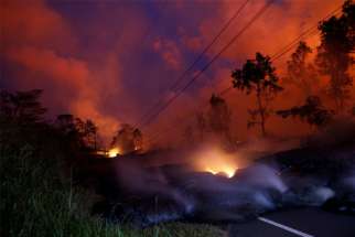 Volcanic gases rise from the Kilauea lava flow that crossed Pohoiki Road near Pahoa, Hawaii, May 28.