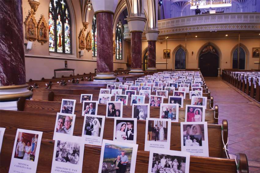 Photos of the couples participating online are displayed in the pews at Vancouver’s Holy Rosary Cathedral.