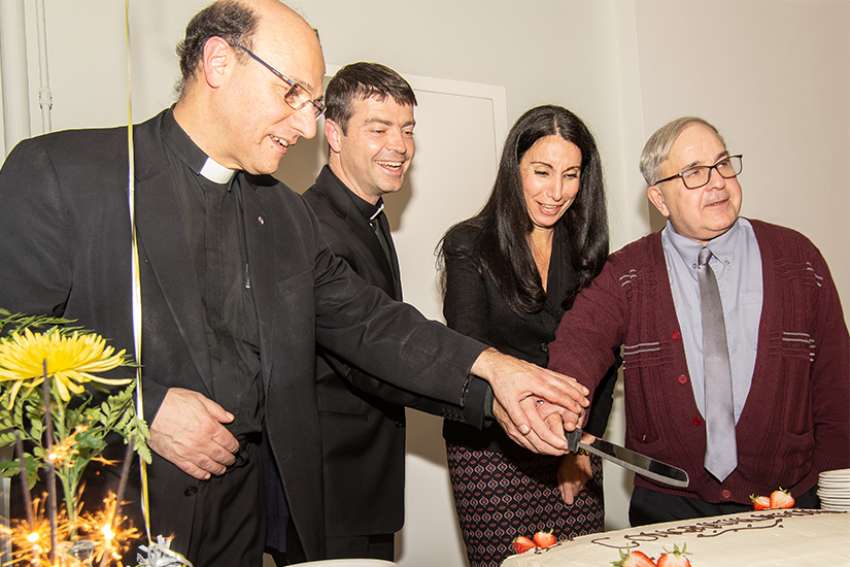 Scripture scholar Msgr. Bob Nusca, left, historian Fr. Seamus Hogan, theologian Josephine Lombardi and homiletics expert Deacon Peter Lovrick cut into a cake at a celebration of their recent publications. Lovrick pubished A Practical Guide to Catholic Preaching in 2016, Lombardi brought out Experts in Humanity in 2016, Hogan’s Extraordinary Ordinaries arrived this year, and Nusca’s Contemplating the Faces of Jesus in the Book of Revelation hit bookshelves this year. 