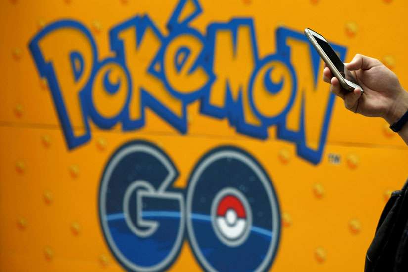A man uses a mobile phone in front of an advertisement board bearing the image of &quot;Pokemon Go&quot; at an electronic shop in Tokyo on July 27, 2016.
