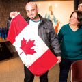 Fady Meera proudly waves the Canadian flag as his mother Landa and two of his siblings, brother Rani and sister Vahlia, look on.