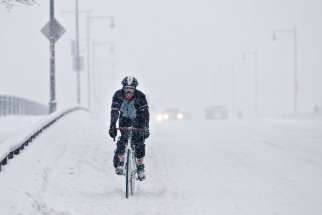 A man rides his bike across a bridge during a winter storm in Boston Feb. 5. 