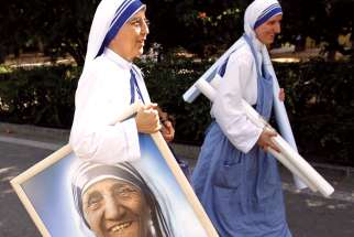 In this 2011 file photo, a member of the Missionaries of Charity carries a portrait of St. Teresa of Kolkata in Madrid’s Buen Retiro park.