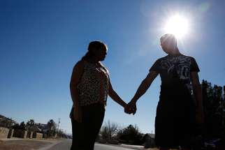 Thalia Hernandez and her boyfriend, Rafael Muriel, stand on a street Feb. 15 in the El Paso, Texas, neighborhood where they live. Hernandez at age 17 had fled her home in Mexico out of fear for her life and came to the U.S.