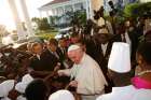 Pope Francis greets people as he arrives with Ugandan President Yoweri Museveni at the State House in Entebbe, Uganda, Nov. 27.