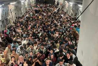 Evacuees crowd the interior of a U.S. Air Force C-17 Globemaster III transport aircraft carrying nearly 700 Afghans from Kabul to Qatar Aug. 15.