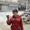 A boy holds the remains of a mortar in this handout picture taken Feb. 23 by a member of the Syrian National Council in a neighborhood in Homs. 