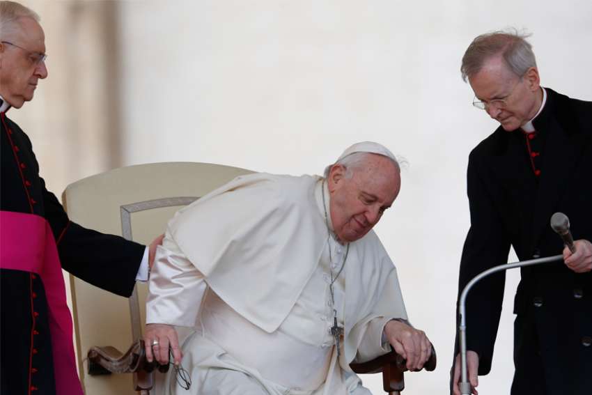 Pope Francis grimaces in pain as he gets up from his chair during the general audience in St. Peter&#039;s Square at the Vatican in this April 20, 2022, file photo. On his doctors&#039; advice because of ongoing problems with his knee, the pope will not travel to Congo and South Sudan in early July, the Vatican announced June 10.
