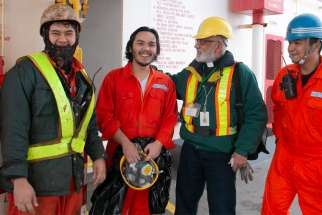 Deacon Dileep Athaide, second from right, a chaplain from the Archdiocese of Vancouver, British Columbia, chats with crew members aboard a Japanese coal ship March 15, 2019.