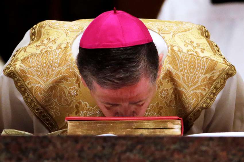 Archbishop Blase J. Cupich kisses the Book of the Gospels on the altar during his installation Mass at Holy Name Cathedral in Chicago Nov. 18.