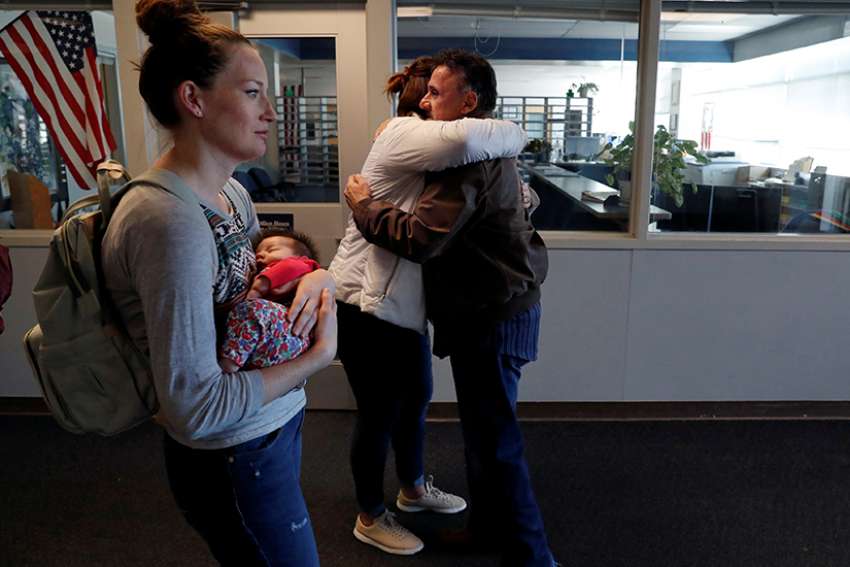 Retired principal Frank DeAngelis gives a hug to Columbine High School alum Rachel Burr March 17, 2018, after a group of former students and survivors took a private tour of their school in Littleton, Colo. 
