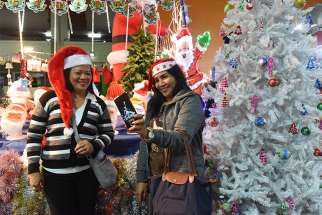 Angeline Fernando and Vangie Lapada, foreign workers from the Philippines, take a selfie wearing Santa hats at the Christmas market in the central bus station in Tel Aviv, Israel, Dec. 9. The market offers an opportunity for foreigners to buy decorations for Christmas in the Jewish state. 