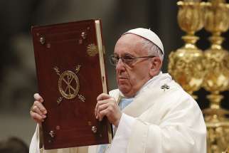 Pope Francis raises the Book of the Gospels during a Mass marking the feast of Mary, Mother of God, in St. Peter&#039;s Basilica at the Vatican Jan. 1.