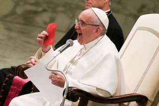 Pope Francis shows a free ticket during his Wednesday general audience in Paul VI Hall at the Vatican on Jan. 11, 2017.