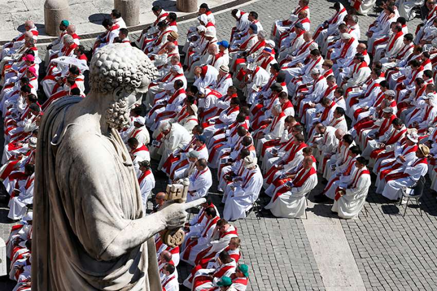 Priests sit below the statue of St. Peter as Pope Francis celebrates Mass marking the feast of Sts. Peter and Paul in St. Peter&#039;s Square at the Vatican June 29. In an Aug. 20 letter to all Catholics, the pope blamed clericalism for helping to support and perpetuate sexual abuse committed by clergy.