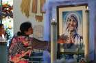 A woman reaches to touch a painting of Mother Teresa at Christo Rei parish in Mississauga, Ont., Sept. 4. The parish celebrated a Mass in the new saint’s honour on the day she was named St. Teresa of Calcutta. The Mass was celebrated by Cardinal Luis Antonio Tagle of the Philippines.