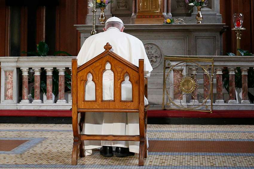 Pope Francis prays in front of a candle in memory of victims of sexual abuse as he visits St. Mary&#039;s Pro-Cathedral in Dublin Aug. 25, 2018. Pope Francis has revised and clarified norms and procedures for holding bishops and religious superiors accountable in protecting minors as well as in protecting members of religious orders and seminarians from abuse. 