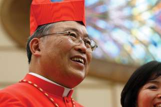 Cardinal Yeom Soo-jung of Seoul, South Korea, poses with a guest during a reception for new cardinals in Paul VI hall at the Vatican 2014.