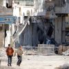 Children run along a street with rubble from buildings damaged by what activists said was a government airstrike in the Aleppo, Syria, Dec. 5. Middle East bishops and patriarchs say the resolution of the Israeli-Palestinian conflict is key to peace throu ghout region.