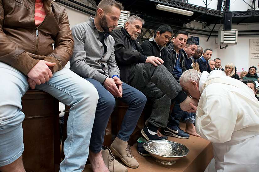 Pope Francis kisses the foot of an inmate during Holy Thursday Mass March 29 at Regina Coeli prison in Rome. The pope celebrated Mass and washed the feet of 12 inmates at the prison.