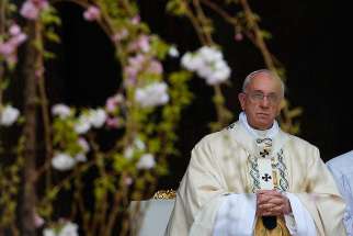 Pope Francis is pictured through flowers as he celebrates Easter Mass in St. Peter&#039;s Square at the Vatican in this April 5, 2015, file photo. As part of an ecological initiative, the Vatican announced that it will plant tulips from the 2016 Easter Sunday Mass in the Vatican Gardens and also give them to various pontifical colleges and institutions. 