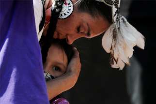 A woman embraces her daughter during a rally at the former Kamloops Indian Residential School in Kamloops, British Columbia.