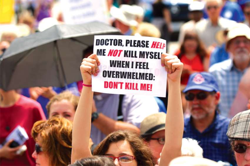 A woman holds up a sign during a rally against assisted suicide in 2016 on Parliament Hill in Ottawa.
