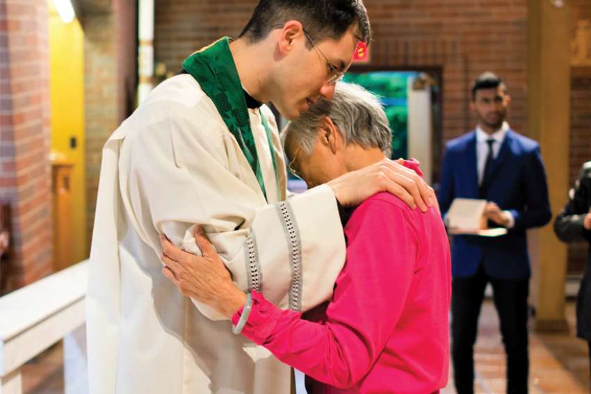Fr. Justin Huang blesses a St. Anthony of Padua parishioner. A new initiative is pairing priests in the Archdiocese of Vancouver with women who will be spiritual mothers for them.