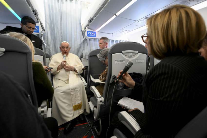 Pope Francis listens to a question from Spanish journalist Eva Fernández during his flight from Hungary back to Rome April 30, 2023.