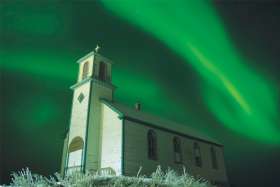 he old Holy Name of Mary Mission in Tsiigehtchic, N.W.T., is bathed in the northern lights. The church is side by side with the new church.