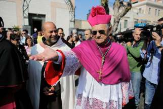 Latin Patriarch Fouad Twal of Jerusalem gestures during a procession in Haifa, Israel, May 11. Patriarch Twal said a spate of attacks he described as acts of terror against the church were poisoning the atmosphere ahead of this month&#039;s visit by Pope Fran cis, and urged Israel to arrest more perpetrators. 