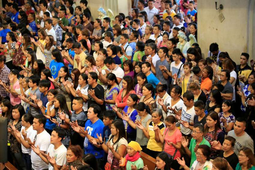 Churchgoers sing during Mass Sept. 18 at the National Shrine of Our Mother of Perpetual Help in Manila, Philippines. 