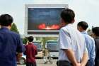 North Koreans watch a news report of an intermediate-range ballistic missile launch on a big screen at Pyongyang station in Pyongyang, North Korea, Aug. 30. 