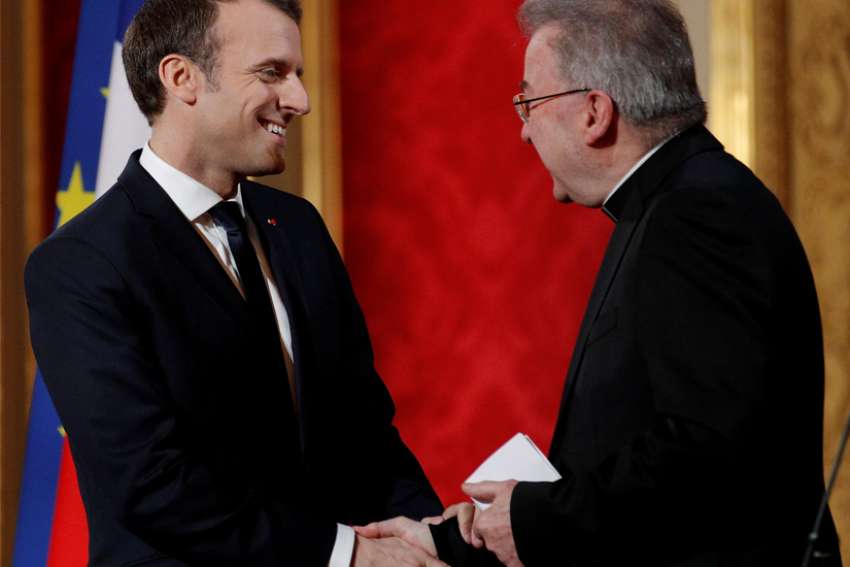 French President Emmanuel Macron greets Italian Archbishop Luigi Ventura as he presents his New Year wishes to members of the diplomatic corps at the Elysee Palace in Paris Jan. 4, 2018. The Vatican said it has lifted diplomatic immunity of the papal nuncio, who has been under investigation in France for allegedly sexually assaulting a city official.