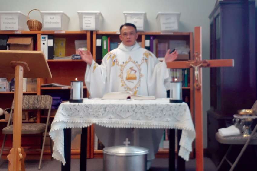 Fr. Mario Infante presides at Mass in the storeroom of his parish office in Brooks, Alta.
