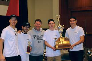 Jason Rehel, centre, with some of his prized St. Brother André High School students at the Toronto Automotive Technology Competition. The team of Sam Luff and Vincent Servinis, right, placed first, with classmates Ethan Chong and Alessandro Albi second. 