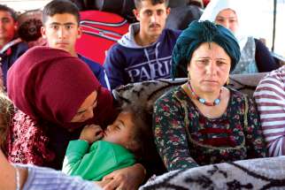 Displaced Syrian families, who fled violence after the Turkish offensive against Syria, sit in a bus on their way to camps in the Iraqi province of Dahuk Oct. 16, 2019. In an Oct. 17 plea, Archbishop Timothy P. Broglio of the U.S. Archdiocese of the Military Services, chairman of the U.S. bishops’ Committee on International Justice and Peace, urged countries choose “dialogue over confrontation” to resolve their differences.