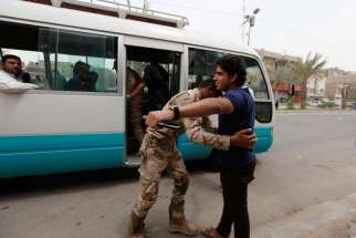 A member of the Iraqi security forces searches a man at a checkpoint in Baghdad June 11. Baghdad will cooperate with Kurdish forces to drive militants out of Mosul, the country&#039;s second-biggest city. Christians are among 500,000 fleeing Mosul after Islam ist forces seized it in early June.